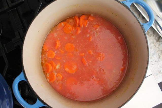 Add the tomatoes to the onion and carrots.